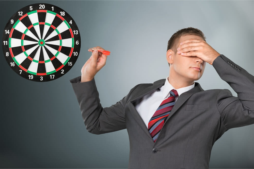Young businessman playing darts